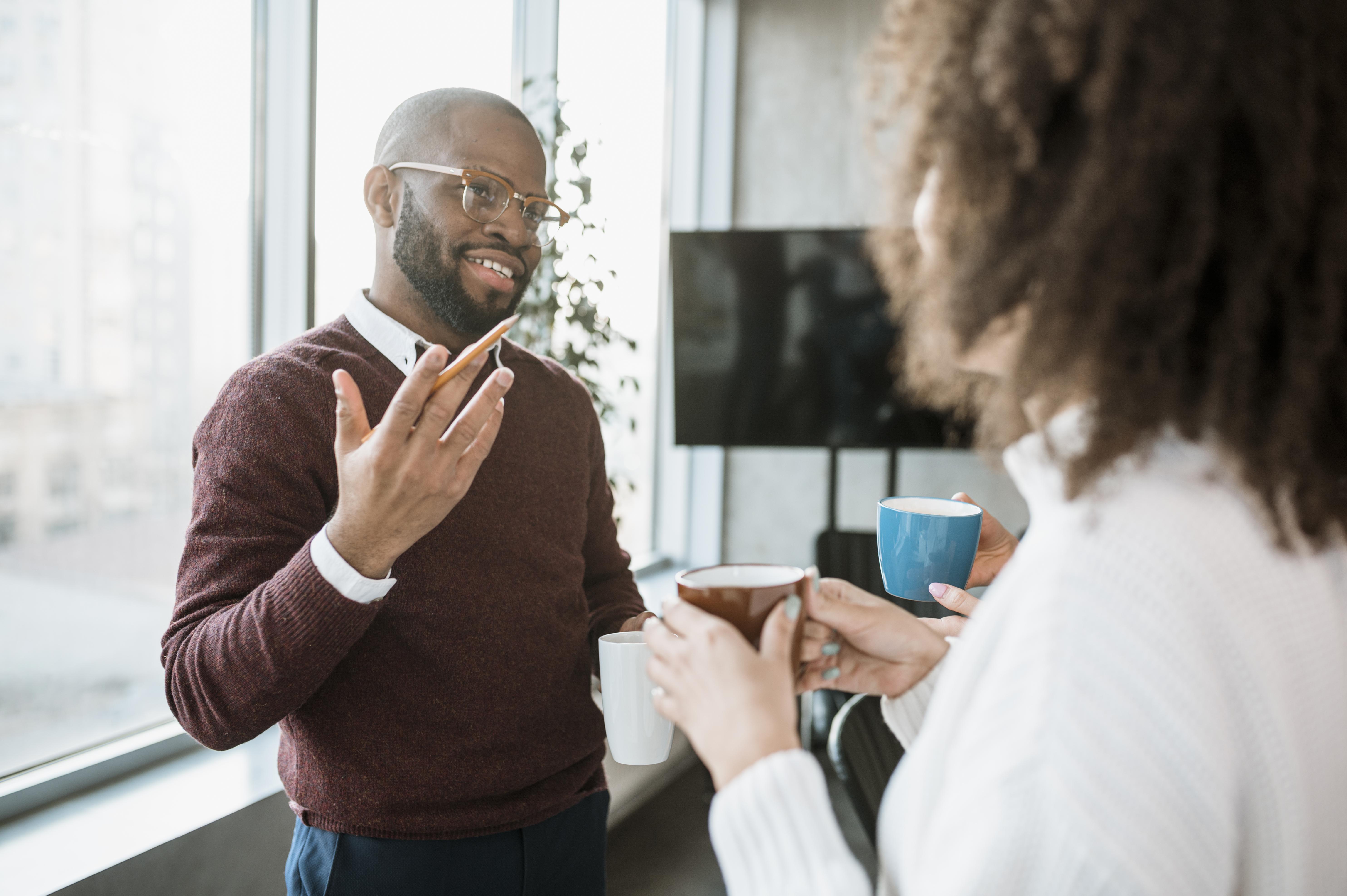 Office workers discussing a project using sticky notes on a board.